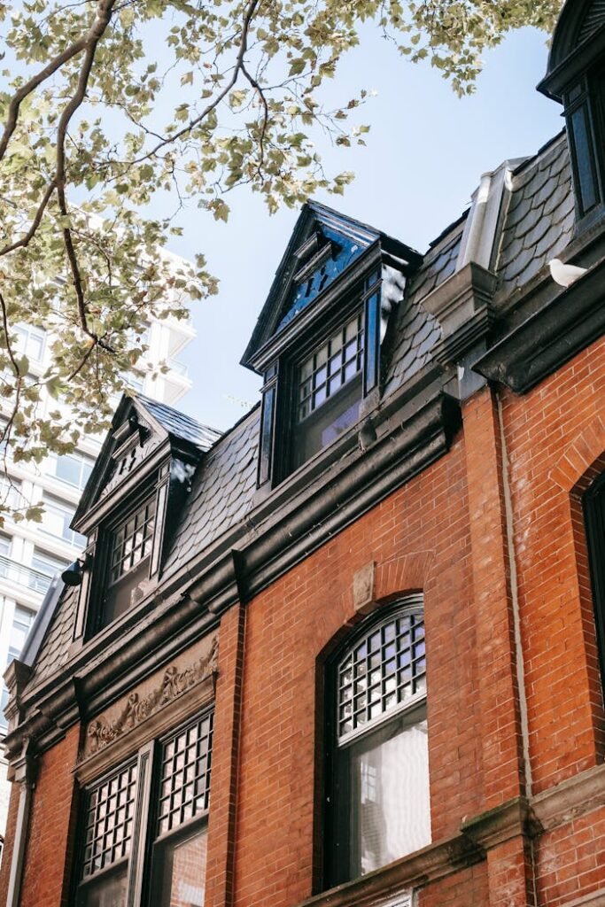 Brick house detail with mansard windows on sunny day